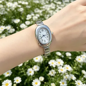Detailed view of an elegant silver oval quartz watch with a modular stainless steel strap