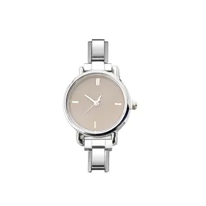 Close-up of minimalist stainless steel watch with a beige concentric circle dial