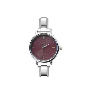 Detail view of round quartz watch with burgundy dial and silver modular steel strap