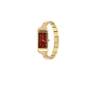 Detail view of the elegant rectangular watch with a burgundy dial and gold modular strap