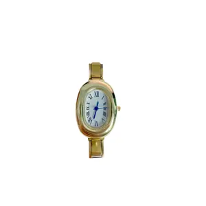 Vintage gold oval quartz watch with blue hands and a modular stainless steel strap