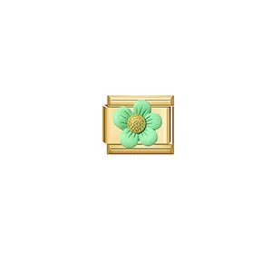Macro detail of a golden modular bracelet charm featuring a light green flower ornament