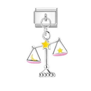 Detail eines italienischen Charm-Links mit silberner Waage und rosa Emaille-Akzenten