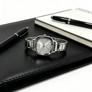 Detailed view of the silver stainless steel square quartz watch on a leather desk pad.