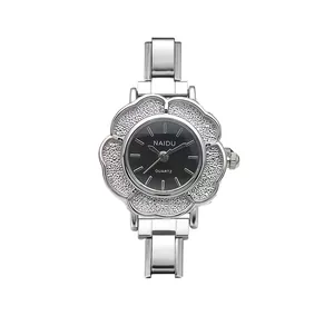 Nahaufnahme der eleganten silbernen Quarz Uhr in Kamelienform mit schwarzem Zifferblatt