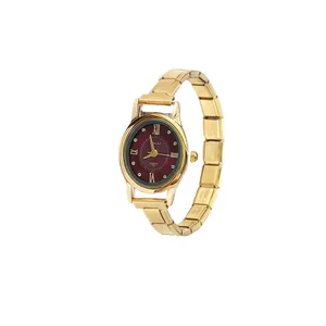 Detail view of a gold modular quartz watch with a deep red oval dial and Roman numerals.
