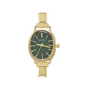 Primo piano di un orologio ovale dorato minimalista con quadrante verde scuro e cinturino