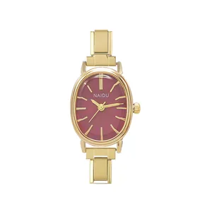 Dettaglio di un orologio al quarzo ovale dorato minimalista con quadrante rosso