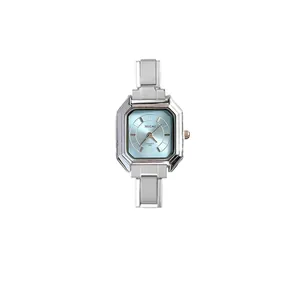 Detalle de la esfera cuadrada azul claro en un reloj de mujer de color plateado
