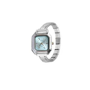 Detalle de un reloj de cuarzo modular plateado para mujer con esfera octogonal azul claro