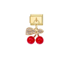 Macro detail of a luxurious gold modular bracelet charm with red crystal cherries