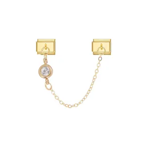 Detailed view of a golden modular bracelet link charm with a sparkling clear crystal