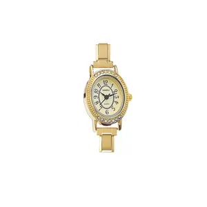 Close-up detail of a gold-toned vintage watch with rhinestone bezel and modular strap