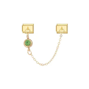 Close-up detail of a modular jewelry link with a green star stone and gold chain