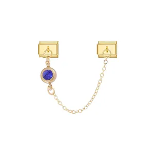 Detail of gold modular charm with blue gemstone pendant on a delicate connecting chain