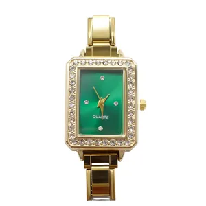 Detailed view of gold rectangular quartz watch featuring a green dial and rhinestone bezel