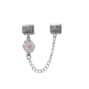Detailansicht eines rosa Rosenanhängers an einer Silberkette für DIY-Armbänder.
