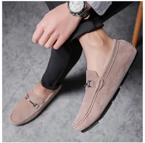Detailed view of men's tan suede loafers with metal buckle design