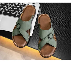 Detailed view of men's green cross-strap slide sandals with buckle and stitched sole