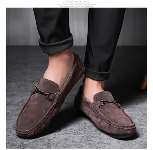 Close-up detail of men's brown suede moccasins with stylish metal buckle accent