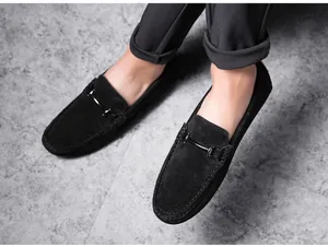Detailed view of men's black suede loafers featuring a sleek decorative metal bit.