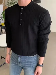 Detail showing the ribbed texture of a men's black knit sweater with henley button neck