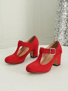 Dettaglio di eleganti scarpe Mary Jane rosse in finto scamosciato con cinturino a T.