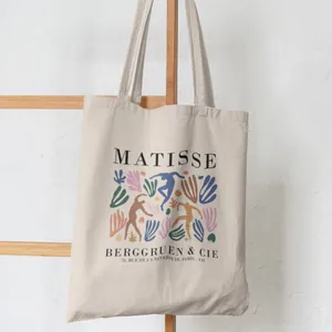 Detailed view of cream canvas tote bag with Matisse art print hanging on a ladder