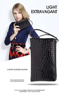 Macro-detail van de glanzende zwarte clutch met krokodillenpatroon en polsband.