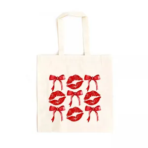 Detailed view of canvas tote bag with red bow and watercolor kiss print