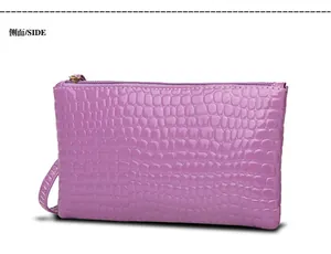 Paarse clutch met krokodillenpatroon en polsbandje, detailweergave van de tas