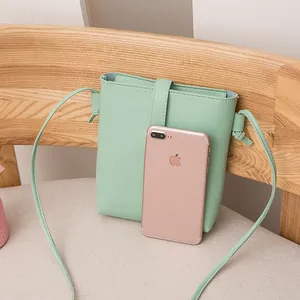 Minimalist mint green casual bucket bag for women shown with a smartphone for size reference