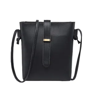 Elegant minimalist black flat grain leather crossbody bucket bag with gold clasp accent