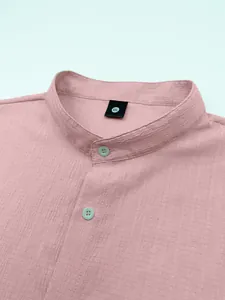 Close-up of men's casual shirt featuring mandarin collar and textured pink fabric.