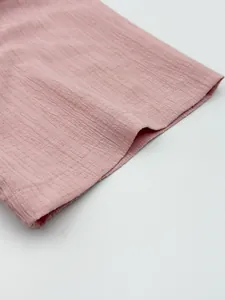Macro view showing the breathable pink textured fabric of a men's casual summer shirt