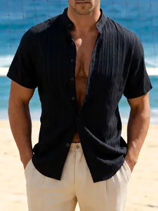 Close-up detail of men's black textured short sleeve band collar shirt at the beach