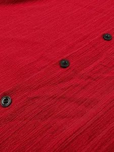 Detail showing red textured fabric and black buttons on a men's casual short sleeve shirt