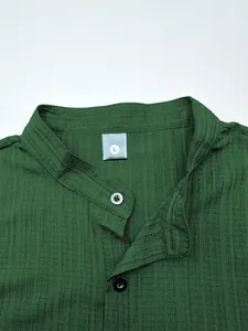 Detailed close-up view of dark green waffle texture fabric on a casual men's short sleeve shirt
