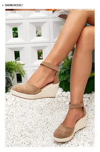 Détail de sandales compensées marron en daim avec semelle plateforme en espadrille