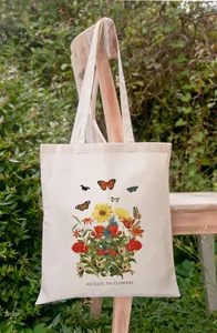 Canvas draagtas met 'No Rain No Flowers' bloemenprint hangend in een tuinsetting