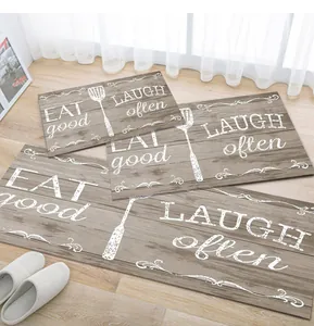 Detail of rustic wood grain kitchen mats set with Eat Good and Laugh Often quotes