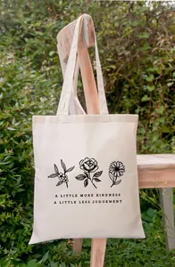 Gedetailleerde weergave van canvas draagtas met bloemenprints en inspirerende tekst