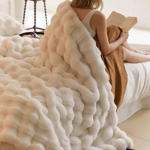 Détail d'une couverture douce en fausse fourrure blanche à bulles dans une chambre cosy