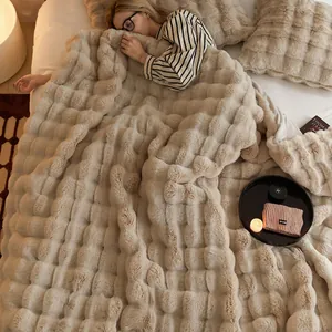 Couverture douillette beige en fausse fourrure à bulles dans une chambre chaude.
