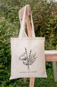 Detail van de bloemenprint 'No Rain No Flowers' op een natuurlijke canvas tas