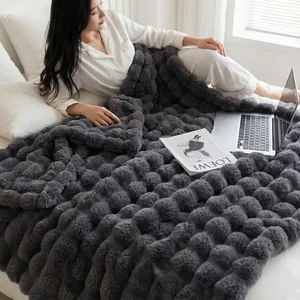 Détail d'une couverture grise épaisse en fausse fourrure avec texture de bulles