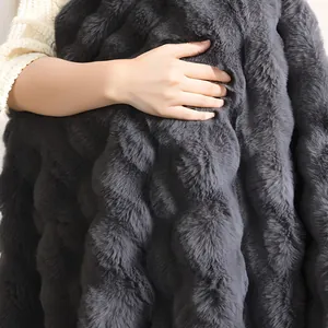 Gros plan détaillé montrant la texture douce d'une couverture en fausse fourrure grise
