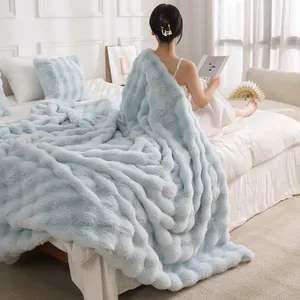 Luxueuse couverture en fausse fourrure bleue Toscane présentée dans une chambre douillette