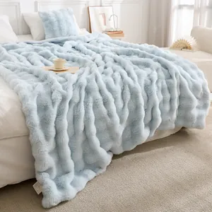 Gros plan d'une couverture bleu clair en fausse fourrure de Toscane sur un lit