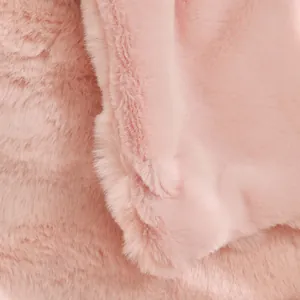 Gros plan de la texture douce de la couverture en fausse fourrure rose à fibres denses.